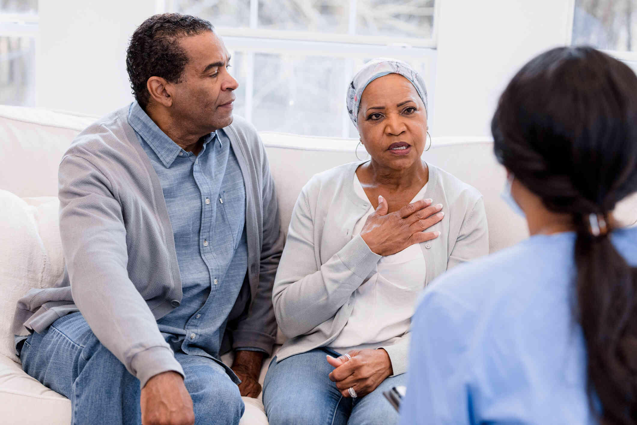 A couple is at their therapy session, the woman is discussing something while her husband listens intently.